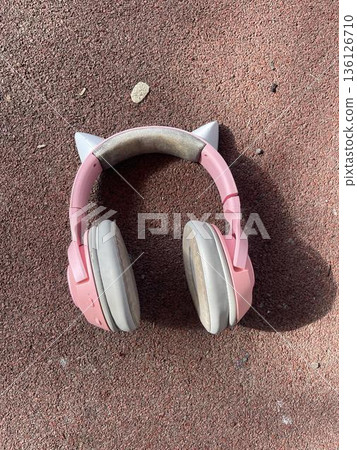 pink headphones are lying on the playground. top view 136126710