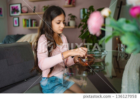 Girl mixing ingredients in bowl in home kitchen Girl mixing ingredients in bowl in home kitchen 136127058