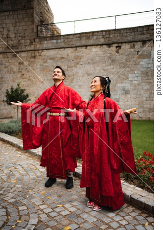 Interracial couple celebrating wedding wearing traditional red Hanfu Interracial couple celebrating wedding wearing traditional red Hanfu 136127083