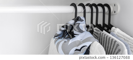 Minimal wardrobe background with clothes on hangers and copy space Minimal wardrobe background with clothes on hangers and copy space 136127088