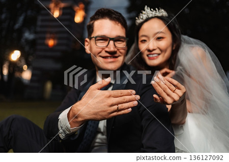 Happy bride and groom displaying their wedding rings after the c Happy bride and groom displaying their wedding rings after the c 136127092