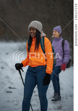 Two people enjoying winter hiking on a snowy trail Two people enjoying winter hiking on a snowy trail 136127219