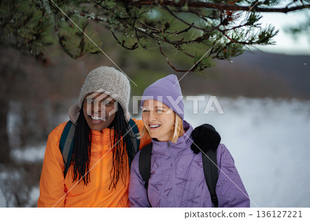 Diverse women friends enjoying winter hiking outdoors together Diverse women friends enjoying winter hiking outdoors together 136127221