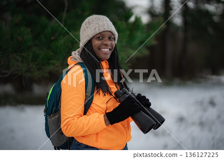 Young woman enjoying birdwatching during winter outdoor adventure Young woman enjoying birdwatching during winter outdoor adventure 136127225