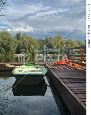 Peaceful Dock by the Lake with a Green Rowboat Peaceful Dock by the Lake with a Green Rowboat 136127281