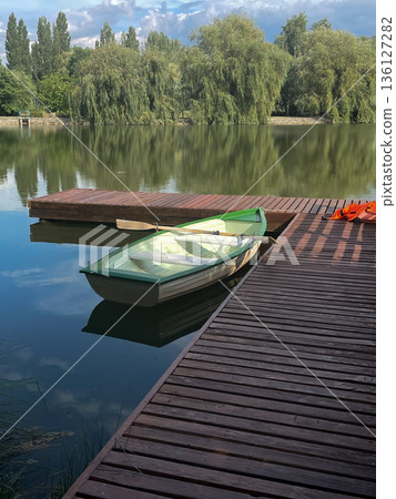 Calm Lake Scene with a Wooden Dock and Suspension Bridge Calm Lake Scene with a Wooden Dock and Suspension Bridge 136127282