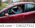 Woman sitting in car in autumn parking lot 136127312
