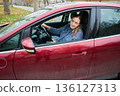 Woman sitting in car in autumn parking lot 136127313