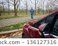 Woman walking and talking on phone near car 136127316