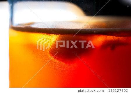 Iced coffee with ice cubes in a glass from a macro perspective Iced coffee with ice cubes in a glass from a macro perspective 136127502