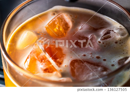 Iced coffee with ice cubes in a glass from a macro perspective Iced coffee with ice cubes in a glass from a macro perspective 136127505