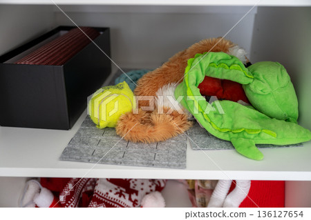 Dog toys on shelf with plush crocodile and tennis ball Dog toys on shelf with plush crocodile and tennis ball 136127654