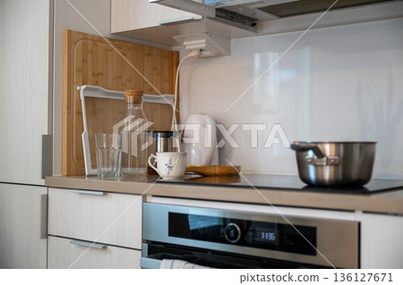 Modern kitchen countertop with kettle cups glass bottle and cooking pot Modern kitchen countertop with kettle cups glass bottle and cooking pot 136127671