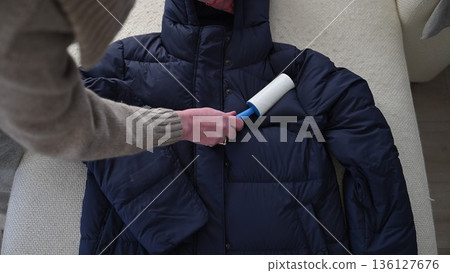 Lint roller cleaning winter jacket removing pet hair and dust 136127676