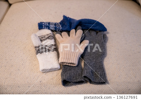 Cozy winter gloves and scarf arranged on soft neutral background Cozy winter gloves and scarf arranged on soft neutral background 136127691