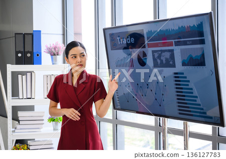 Young Businesswoman Giving Presentation Report to Business Team in the Conference Room, Shows Digital Information Graphics, Pie Charts about Company Growth on TV. 136127783