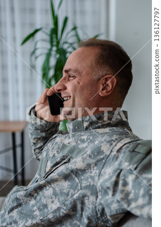 Happy soldier talking on the phone at home 136127797