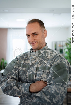 Portrait of a confident soldier smiling with arms crossed 136127801