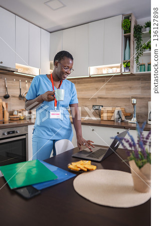 Young female doctor drinking coffee and working from home Young female doctor drinking coffee and working from home 136127898