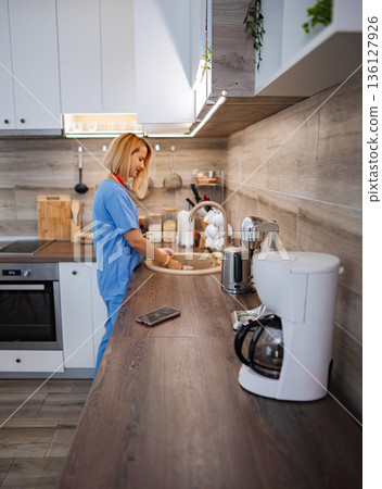 Female Doctor Washing Dishes in her Modern Kitchen after Work Female Doctor Washing Dishes in her Modern Kitchen after Work 136127926