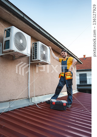 HVAC technician checking air conditioning units on a roof HVAC technician checking air conditioning units on a roof 136127929