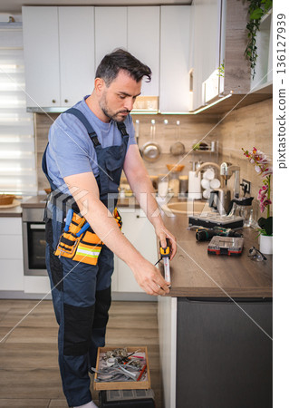 Handyman measuring kitchen counter using tape measure Handyman measuring kitchen counter using tape measure 136127939