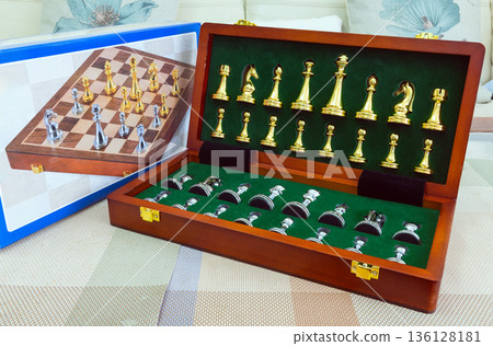 chessboard with golden and silver pieces isolated close-up 136128181