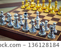 chessboard with golden and silver pieces isolated close-up 136128184