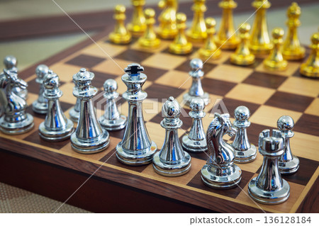 chessboard with golden and silver pieces isolated close-up 136128184