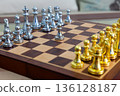 chessboard with golden and silver pieces isolated close-up 136128187