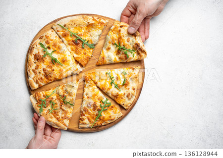 Hands grabbing slices of pizza 136128944
