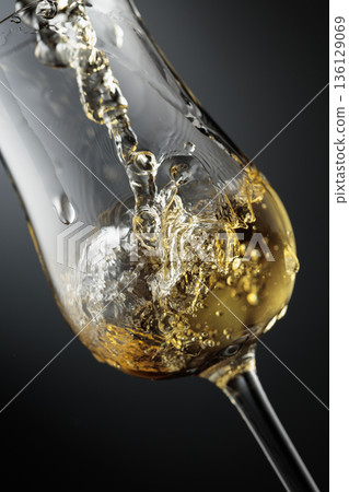 Whiskey is poured is poured into a glass. Whiskey is poured is poured into a glass. 136129069