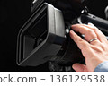 A man holding a video camera and operating the focus 136129538