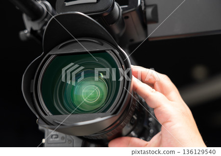 一名男子手持攝影機,正在操作對焦裝置。 一名男子手持攝影機,正在操作對焦裝置。 136129540