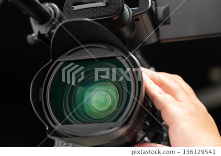 一名男子手持攝影機,正在操作對焦裝置。 一名男子手持攝影機,正在操作對焦裝置。 136129541