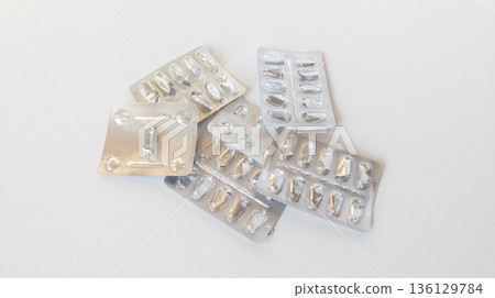 Empty foil blister packs for various tablets and capsules isolated on white background. Used medications. Healthcare and drug concept. 136129784