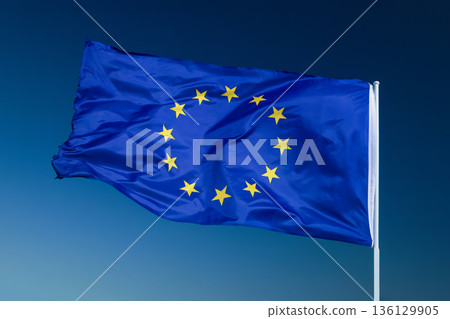 European Union EU flag waving in the wind over blue sky. 136129905