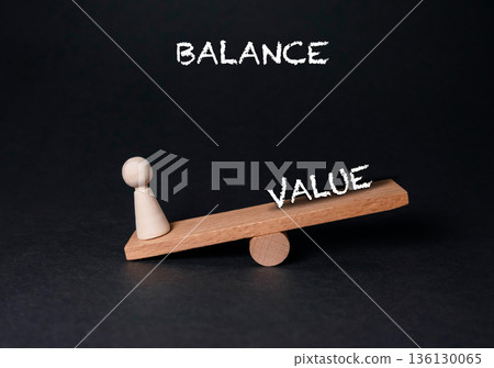 Wooden balance scale with a pawn figure representing value and equilibrium concept Wooden balance scale with a pawn figure representing value and equilibrium concept 136130065