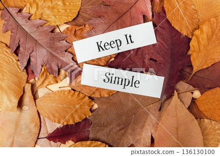Colorful autumn leaves with motivational text Keep It Simple on a rustic wooden background 136130100