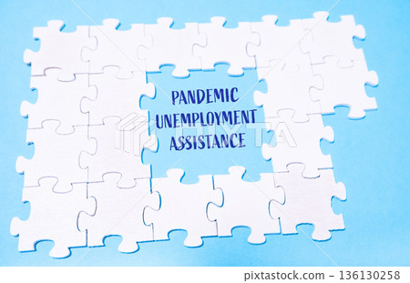 Puzzle pieces forming message about pandemic unemployment assistance on blue background 136130258
