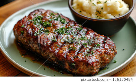 Grilled meatloaf served with creamy mashed potatoes on a rustic wooden table Grilled meatloaf served with creamy mashed potatoes on a rustic wooden table 136130494