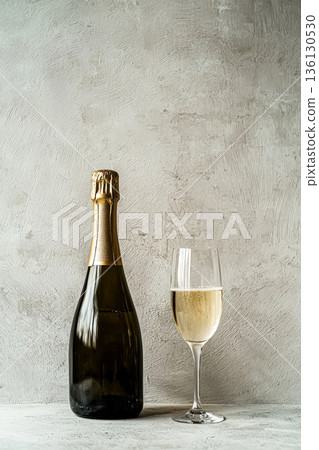 Sparkling wine bottle with glass on textured background showcasing elegance and celebration Sparkling wine bottle with glass on textured background showcasing elegance and celebration 136130530