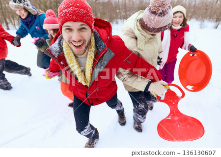 Closeup of smiling man leading friends during winter walk Closeup of smiling man leading friends during winter walk 136130607