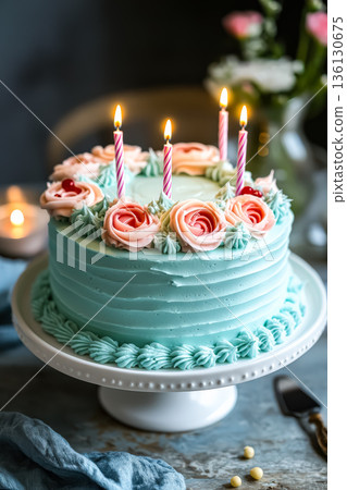 Blue cake with pink and white frosting and four candles on top 136130675