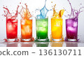 Row of colorful drinks in glasses with a splash of color in the air 136130711