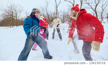 Happy friends playing with snow during winter walk outdoors. 136130728