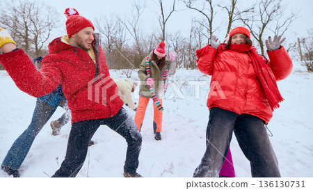 Friends running and throwing snow in winter park. 136130731