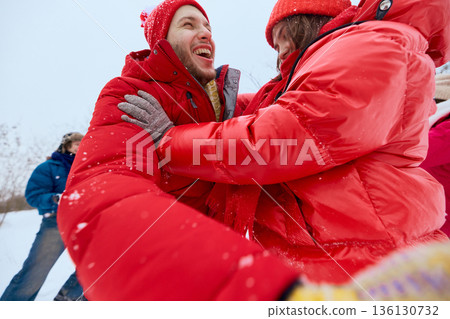 Happy friends enjoying snow game together outdoors. 136130732