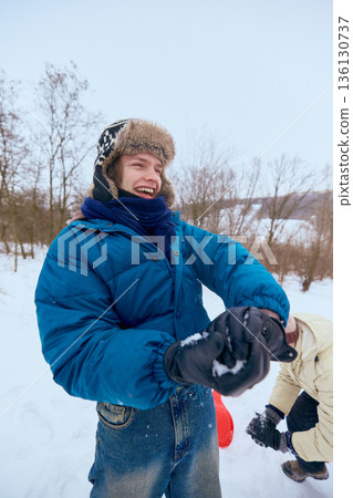 Young man laughing during winter outdoor game. 136130737