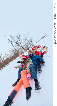 Friends sliding downhill on snow together. Friends sliding downhill on snow together. 136130740